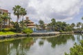 Gorgeous landscape view of hotel grounds with pool, green trees courses and lake against blue sky with white clouds background.