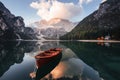 Gorgeous landscape. Wooden boat on the crystal lake with majestic mountain behind. Reflection in the water. Chapel is on