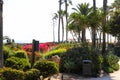 Gorgeous lush green plants and trees with red flowers, palm trees and ocean views with blue sky at Treasure Island Park Royalty Free Stock Photo