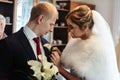 Gorgeous luxury blonde bride putting on boutonniere on the suit Royalty Free Stock Photo