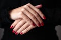 Gorgeous manicure, clssic red color nail polish, closeup photo. Female hands over dark background Royalty Free Stock Photo
