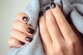 Gorgeous manicure, dark purple tender color nail polish, closeup photo. Female hands over background of casual clothes Royalty Free Stock Photo