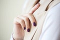 Gorgeous manicure, dark purple tender color nail polish, closeup photo. Female hands over simple background of casual clothes Royalty Free Stock Photo