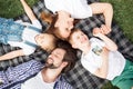 Gorgeous members of family are lying on the blanket on the grass. Man is looking at daughter. Woman is looking at son Royalty Free Stock Photo