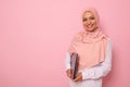 Gorgeous Muslim woman in stylish traditional religious outfit with covered head in pink hijab smiling with toothy smile posing