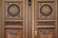 Gorgeous ornate natural wood door panels with elegant monogram ornaments and antique handles. Details of Paris door