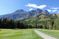 Gorgeous par 4 on a golf course surrounded by forest and big mountains in the background, on a beautiful sunny day in Kananaskis,