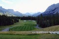 Gorgeous par 3 on a golf course surrounded by forest and big mountains in the background, on a beautiful sunny day in Kananaskis,