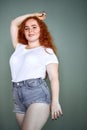 Gorgeous plus size young redhaired girl posing studio