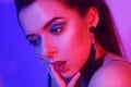 Gorgeous portrait of a girl in neon. Red-blue color. Festive makeup, shadow with sparkles