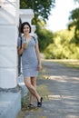 Beautiful woman with a green cocktail. A pretty woman leaning on a wall on a natural background. Casual fashion concept. Royalty Free Stock Photo