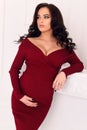 Gorgeous pregnant woman with long dark hair posing at bedroom Royalty Free Stock Photo
