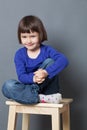 Gorgeous preschool child sitting in holding crossed legs