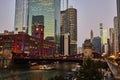 Gorgeous red and blue lights on red brick building along canal with bridge at dawn, Chicago tourism