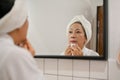 Gorgeous 60s aged Asian woman removing her makeup with makeup remover and cotton pad Royalty Free Stock Photo
