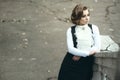 Gorgeous sad woman with elegant Victorian hairstyle leaning on the old stair railing and looking aside