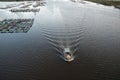 Gorgeous scenery of a boat running strikingly in the middle of a river with a floating village Royalty Free Stock Photo