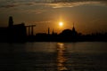 Gorgeous scenic of Thai temple silhouettes and Industrial factory along Chao phraya river over sun at sunrise