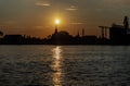 Gorgeous scenic of Thai temple silhouettes and Industrial factory along Chao phraya river over sun at sunrise