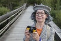 Gorgeous senior tourist snapping a picture with vintage camera