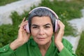 Gorgeous senior woman listening to music in park