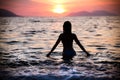 Gorgeous fit woman silhouette swimming in sunset.Free happy woman enjoying sunset. Beautiful woman in water embracing the gol Royalty Free Stock Photo