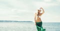 Gorgeous, girl wearing hat, bikini and green silk on the be Royalty Free Stock Photo