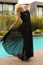 Gorgeous woman with blond hair wears elegant black dress Royalty Free Stock Photo