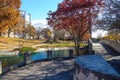 A gorgeous shot of an autumn landscape in the park with a stone bridge over the lake surrounded by gorgeous autumn colored trees