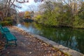 A Gorgeous Shot Of The Lake In The Park With Green Park Benches Surrounded By Gorgeous Autumn Colored Trees And Plants
