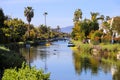 A gorgeous shot of the lush green waters of the canal with colorful boats and lush green trees and plants reflecting off the water Royalty Free Stock Photo