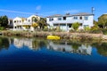 A gorgeous shot of the lush green waters of the canal with colorful boats and lush green trees and plants reflecting off the water Royalty Free Stock Photo