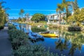 A gorgeous shot of the lush green waters of the canal with colorful boats and lush green trees and plants reflecting off the water Royalty Free Stock Photo