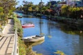 A gorgeous shot of the lush green waters of the canal with colorful boats and lush green trees and plants reflecting off the water Royalty Free Stock Photo