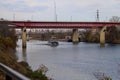 A gorgeous shot of the rippling waters of the Cumberland river with a white tug boat sailing under a red metal bridge Royalty Free Stock Photo