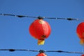 A gorgeous shot of rows of red Chinese lanterns hanging from black cables with a blue sky background at Atlantic Station