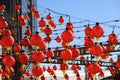 A gorgeous shot of rows of red Chinese lanterns hanging from black cables with a blue sky background at Atlantic Station
