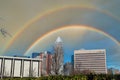 A gorgeous shot of skyscrapers and the buildings in the cityscape with a blue sky and a rainbow in the clouds in downtown