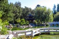 A gorgeous shot of the stone bridge with 3 circles over the green lake surrounded by lush green and autumn colored trees