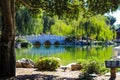 A gorgeous shot of the stone bridge with 3 circles over the green lake surrounded by lush green and autumn colored trees