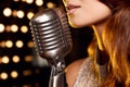 Gorgeous singer woman in with retro microphone on restaurant stage Royalty Free Stock Photo