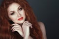 Gorgeous smiling red headed woman with beautiful make up, her hands crossed under her chin Royalty Free Stock Photo