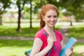 Gorgeous smiling student holding notebooks looking at camera Royalty Free Stock Photo