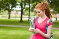 Gorgeous smiling student holding notebooks texting Royalty Free Stock Photo