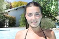 Smiling teenage girl sitting in pool near home Royalty Free Stock Photo