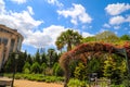 A gorgeous spring landscape in the garden with lush green trees, grass and plants with red flowers and blue sky with clouds Royalty Free Stock Photo