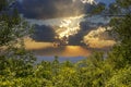 a gorgeous spring landscape with lush green trees and plants and mountains covered in lush green foliage with powerful clouds Royalty Free Stock Photo