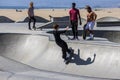 a gorgeous spring landscape at Venice Beach Skatepark at Venice Beach with young men riding skateboards and a sandy beach Royalty Free Stock Photo