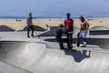 a gorgeous spring landscape at Venice Beach Skatepark at Venice Beach with young men riding skateboards and a sandy beach Royalty Free Stock Photo