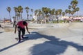 a gorgeous spring landscape at Venice Beach Skatepark at Venice Beach with young men riding skateboards and people watching Royalty Free Stock Photo